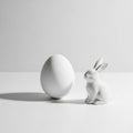 Beautiful cute white ceramic Easter egg and adorable bunny figurine on clean minimalist white background Royalty Free Stock Photo