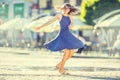 Beautiful cute young girl dancing on the street from happiness.Cute happy girl in summer clothes dancing in the sun Royalty Free Stock Photo