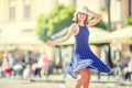 Beautiful cute young girl dancing on the street from happiness.Cute happy girl in summer clothes dancing in the sun