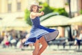 Beautiful cute young girl dancing on the street from happiness.Cute happy girl in summer clothes dancing in the sun Royalty Free Stock Photo