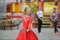 Beautiful dancer in a red dress. Beautiful young girl dancing in a red dress. Dance in public. Talented kid does dancing