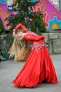 Beautiful dancer in a red dress. Beautiful young girl dancing in a red dress. Dance in public. Talented kid does dancing