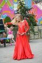 Beautiful dancer in a red dress. Beautiful young girl dancing in a red dress. Dance in public. Talented kid does dancing