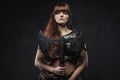 Beautiful woman viking with two handed axe in dark background