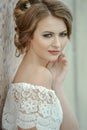 Beautiful dark blonde woman with bright make-up and creative romantic hairstyle.