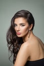 Beautiful dark brown hair woman. Fashion model with long perfect hairstyle, makeup and jewelry earrings