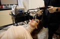 Beautiful dark-haired Hispanic woman getting laser skin resurfacing procedure in wellness spa clinic. Hardware cosmetology