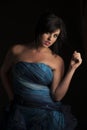 Beautiful dark haired woman playing with hair in evening dress Royalty Free Stock Photo