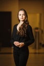 Beautiful dark-haired woman standing and looking in camera