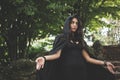 Beautiful dark vampire woman with black mantle and hood Royalty Free Stock Photo