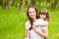 Beautiful daughter embraces young mother in park