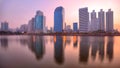 Beautiful dawn scenery of lakeside skyscrapers reflecting on smooth lake water in Benjakiti Park