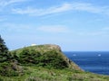 Beautiful day along the coast of Newfoundland viewing the lighthouse on Cape Spear. Boats passing by along the open ocean.