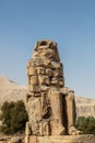 Beautiful daytime view of the Colossi of Memnon. Two large stone figures depicting a seated pharaoh.