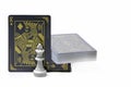 Deck of black playing cards with king card and chess piece standing up.