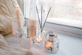 Beautiful decor of white lighted candles in glass candlesticks stand on windowsill, relax place in house, concept of winter cozy Royalty Free Stock Photo