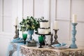 Beautiful decorate table with candles, vase with flowers and wedding cake on the table in studio Royalty Free Stock Photo