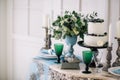 Beautiful decorate table with candles, vase with flowers and wedding cake on the table in studio Royalty Free Stock Photo