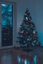 Beautiful decorated and illuminated Christmas tree at night. Christmas interior decor.