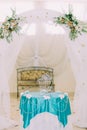 Beautiful decorative birdcage on fancy decorated table under wedding arch in stylysh vintage interior