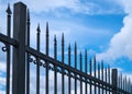 Beautiful decorative cast metal wrought fence against blue sky. Iron guardrail close up
