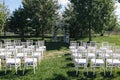 beautiful decorative wedding arch and white chairs