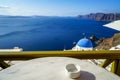 Beautiful deep blue Aegean ocean panoramic sea view and blue church roof from breakfast coffee shop with white marble table