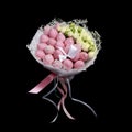 Beautiful delicate bouquet consisting of strawberries in pink chocolate and white roses stands in a glass vase on a black backgrou Royalty Free Stock Photo