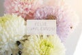 delicate bouquet of multicolored chrysanthemums with a white card with the inscription happy birthday in spanish