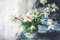 A beautiful delicate bouquet of wild anemone stands on a wooden table in a glass vase. Romantic gift. Copy space. Selective focus Royalty Free Stock Photo