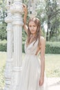 Beautiful delicate bride girl in a light beige wedding dress walks in the garden bright sunny warm day