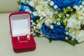 Beautiful delicate wedding bouquet of blue roses and wedding rings of the bride and groom in a red box Royalty Free Stock Photo