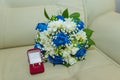 Beautiful delicate wedding bouquet of blue roses and wedding rings of the bride and groom in a red box Royalty Free Stock Photo