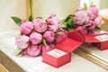 Beautiful delicate wedding bouquet of pink peonies and wedding rings of the bride and groom in a red box Royalty Free Stock Photo