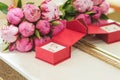 Beautiful delicate wedding bouquet of pink peonies and wedding rings of the bride and groom in a red box Royalty Free Stock Photo