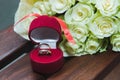 Beautiful delicate wedding bouquet of white roses and wedding rings of the bride and groom in a red box Royalty Free Stock Photo
