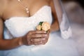 Beautiful delicate wedding boutonier with pink flowers in the hands of the bride, lace dress and veil, morning of the bride