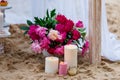 Beautiful, delicate wedding decorations with candles and fresh flowers on the beach Royalty Free Stock Photo