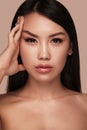 Beautiful delicate woman of oriental type with nude makeup and perfect skin. Beauty face. Spa