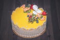 Beautiful delicious yellow cake with fruit and caramel decoration with a smooth jelly surface on a wooden background Royalty Free Stock Photo