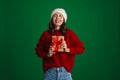 Beautiful delighted girl in knit hat posing with Christmas gift box