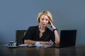 Beautiful depressed and sad business woman working at office laptop computer desk feeling tired looking messy overwhelmed by pape Royalty Free Stock Photo