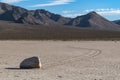 Beautiful desert scene under the sky with  one stone on the ground and hills in the background Royalty Free Stock Photo