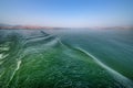 Beautiful detailed view of the green-blue waves on the Sea of Galilee Israel from a boat. in the distance the mainland with its mo Royalty Free Stock Photo