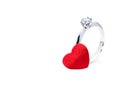 Beautiful diamond ring and a red felt heart on white background Royalty Free Stock Photo