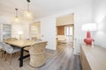 Beautiful dining area decorated with natural fibers in a period building with large windows and exposed brick with plastered and