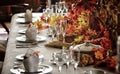 Beautiful dining table decorated with little autumn maple leaves