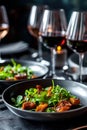 Beautiful dishes and cutlery of a delicious dinner, glasses of wine, in a dark style. Close-up of a gourmet dish with Royalty Free Stock Photo