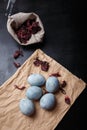 Beautiful DIY painted Easter eggs, dry Hibiscus tea in burlap sack. Easter black wooden background. Top view, copy space, vertical Royalty Free Stock Photo