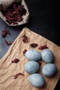 Beautiful DIY painted Easter eggs, dry Hibiscus tea in burlap sack. Easter black wooden background. Top view, copy space, vertical Royalty Free Stock Photo